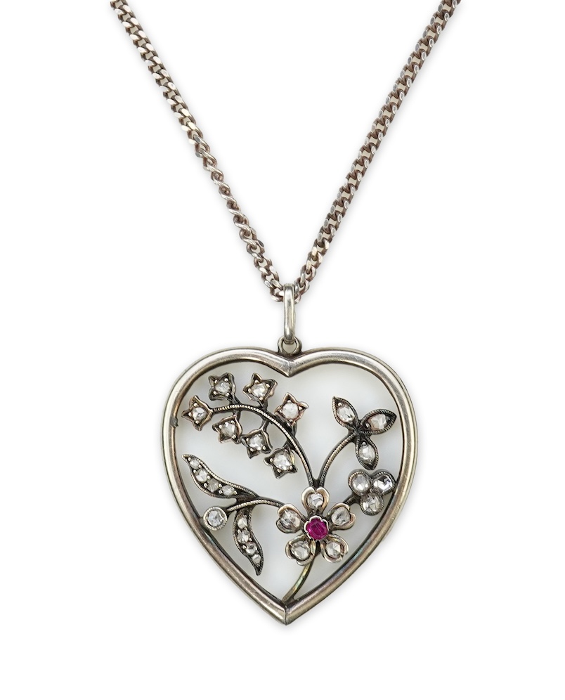 A diamond pendant, designed as a spray of flowers in a heart-shaped frame, set with rose-cut diamonds and a circular-cut ruby, to a later silver chain, pendant 3.1cm, chain length 44cm